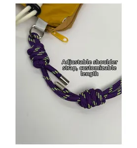 Detail of adjustable woven rope shoulder strap on yellow nylon crossbody bag