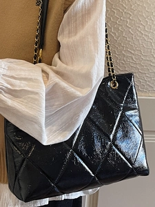 Sac cabas noir brillant matelassé avec bandoulière chaîne dorée, style chic élégant
