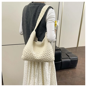 Detail of cream crochet shoulder bag featuring intricate floral knit patterns and soft texture