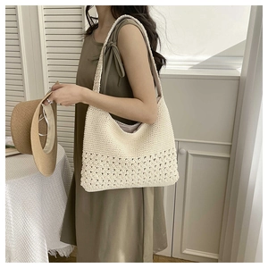Macro detail of hand-crocheted beige shoulder bag showing exquisite openwork knit texture