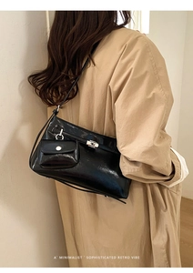 Dettaglio borsa tote in pelle nera lucida con chiusura a scatto e mini tasca laterale