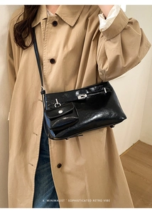 Dettaglio borsa retrò nera lucida con mini astuccio su un trench beige