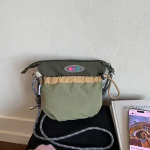 Detail of the multi-colored nylon crossbody bag with durable rope strap and logo patch