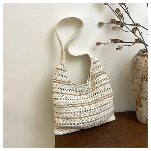 Detail of hand-woven cream tote bag with brown stripes and hollow mesh texture