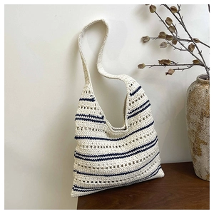 Close-up of hand-woven hollow tote bag with navy stripes and textured shoulder strap