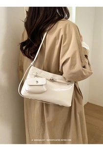 Dettaglio borsa tote in pelle verniciata crema con chiusura argento e mini pochette