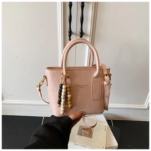 Pink faux leather bucket bag with fashion print and elegant wooden bead charm detail