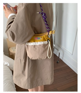 Detail view of the colorful nylon crossbody bag with rope strap shown on a model