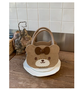 Detailaufnahme der braunen Teddybär Handtasche aus Wildleder mit süßer 3D-Schleife