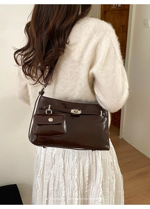 Dettaglio borsa a tracolla retrò marrone scuro con fibbia dorata e mini pochette coordinata