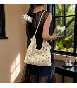 Detail der handgehäkelten creme Hobo-Tasche mit Quasten und modischem Lochmuster Design