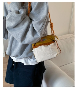 Detail of multi-color patchwork crossbody bag with drawstring closure and rope strap