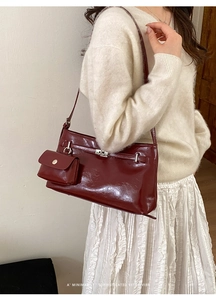 Dettaglio borsa a spalla rosso scuro lucida con chiusura a scatto e mini pochette