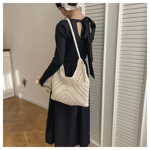 Detail der gewebten Hobo-Tasche mit Häkelmuster und Zierquasten in Cremeweiß