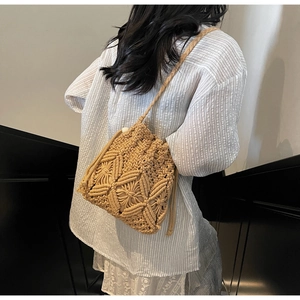 Detail of bohemian hand-woven cotton rope bucket bag with drawstring in khaki color