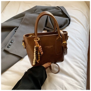 Detailansicht der braunen PU-Leder Handtasche mit farbenfrohem Ethno-Perlenanhänger