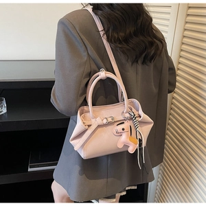 Detailed back view of a light pink crossbody bag with a horse charm and strap