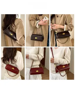 Detail view of stylish rectangular underarm bag with gold metal chain and twist lock closure