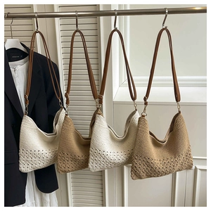 Detail view of woven shoulder bags with intricate openwork patterns and leather straps