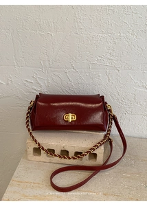 Detailed macro of vintage dark red leather bag with gold metal rotating lock clasp