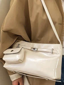 Borsa a tracolla lucida bianco crema con mini portamonete su modella in trench elegante