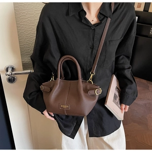 Détails de luxe du sac seau en cuir grainé marron foncé avec accessoires dorés