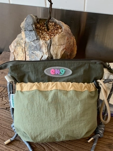 Olive green nylon patchwork crossbody bag with drawstring pocket and thick rope strap