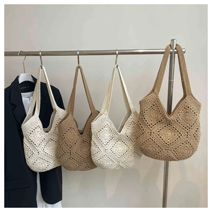 Detail view of woven beach tote bags in four neutral colors on hangers