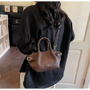Détail du cuir à motif litchi de haute qualité et logo MIKAXIQI PARIS sur le sac marron foncé