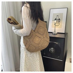 Detail of hand-woven hollow pattern on a khaki crochet shoulder bag in a retro setting