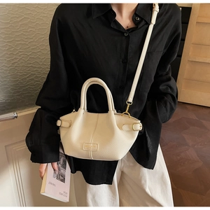 Détail du sac seau en cuir grainé beige avec boucle métallique et bandoulière amovible