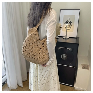 Vue détaillée du sac à bandoulière tissé sur un mannequin dans un intérieur élégant