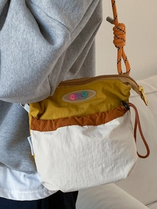 Nylon crossbody bag in mustard, orange, and beige with drawstring pocket and rope strap