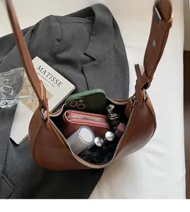 Top view of brown leather crescent bag showing spacious interior and silver zipper