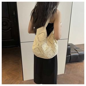 Detailed close-up of a beige crochet shoulder bag showing intricate hollow knit patterns