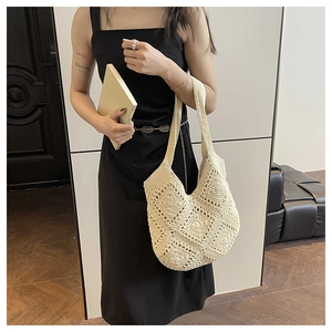 Detail of hand-crocheted hollow square patterns on a beige bohemian shoulder tote bag