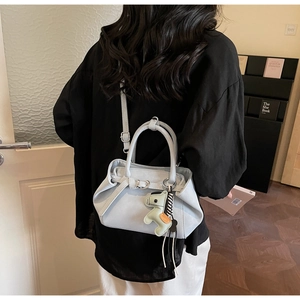 Light blue crossbody bag with animal charm shown on a model for a commute look