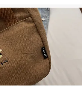 Gros plan détaillé d'un sac en toile marron avec texture gaufrée et broderie girl