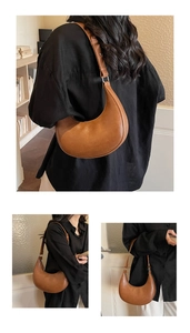 Detail view of a vintage brown crescent bag showing the matte leather texture and silver buckle
