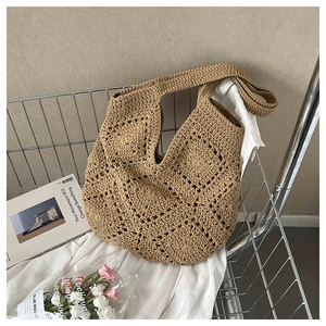 Close-up of bohemian hand-woven crochet shoulder bag with intricate hollow diamond pattern