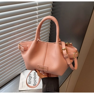 Détail du sac seau rose avec texture cuir grainé et boucle en métal doré ajustable