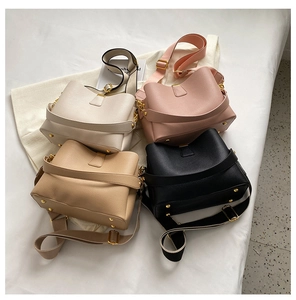 Close-up of four stylish pebble grain PU leather bucket bags in assorted colors and gold hardware
