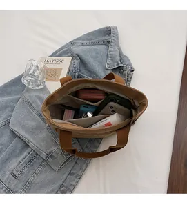 Vue détaillée du sac en toile marron avec plusieurs compartiments internes de rangement