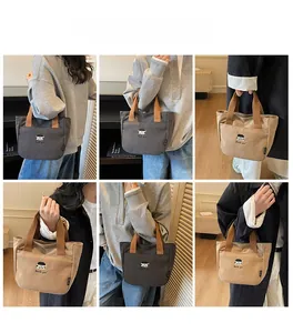 Vues détaillées du sac à main en toile brodé en gris foncé et kaki sur les modèles