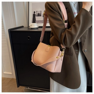 Pink lychee texture bucket bag with gold hardware and wide shoulder strap details