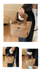 Gros plan détaillé du sac en toile marron avec broderie cartoon et poche avant pratique