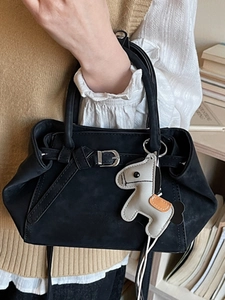 Elegant black matte handbag with silver buckle and decorative pony charm accessory