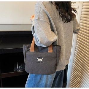 Détail du sac cabas en toile anthracite avec broderie et poche latérale