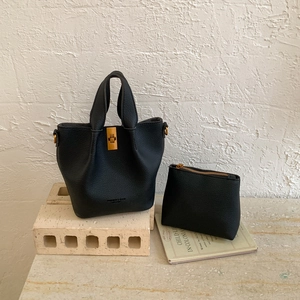 Détail du sac seau noir grainé avec fermoir doré et sa pochette à monnaie assortie