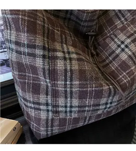 Λεπτομέρεια ρετρό καρό υφάσματος με κορδόνι και κουμπί από κέρατο σε τσάντα ώμου